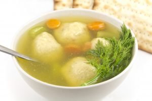 Delicious Matzoh ball soup with crackers wine and dill